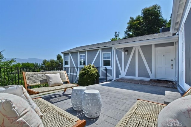 view of patio with fence and a mountain view