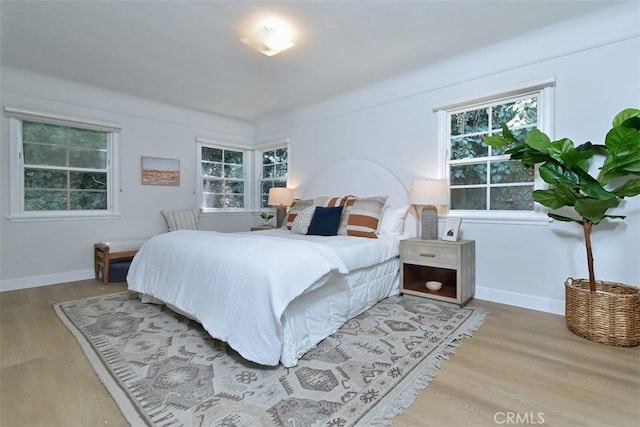 bedroom with baseboards and wood finished floors