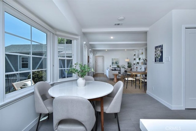 dining area with baseboards and beam ceiling