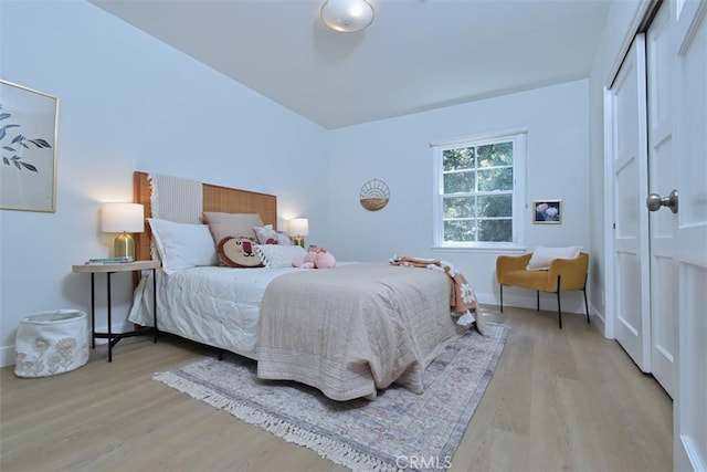 bedroom with a closet, baseboards, and wood finished floors