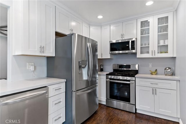 kitchen with dark wood-style floors, appliances with stainless steel finishes, glass insert cabinets, and white cabinets