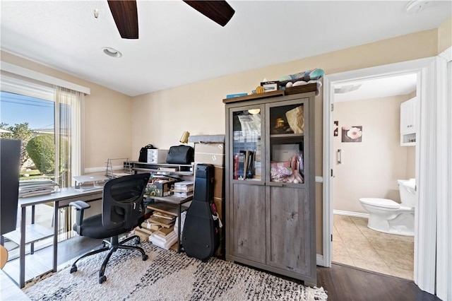 home office featuring a ceiling fan, baseboards, and dark wood-style floors