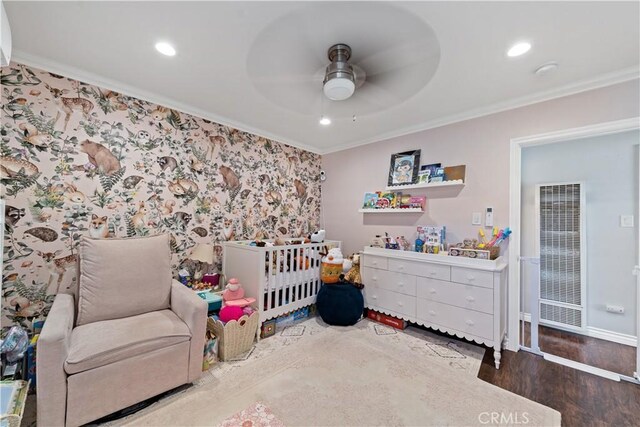 bedroom with recessed lighting, wood finished floors, ornamental molding, a crib, and a heating unit