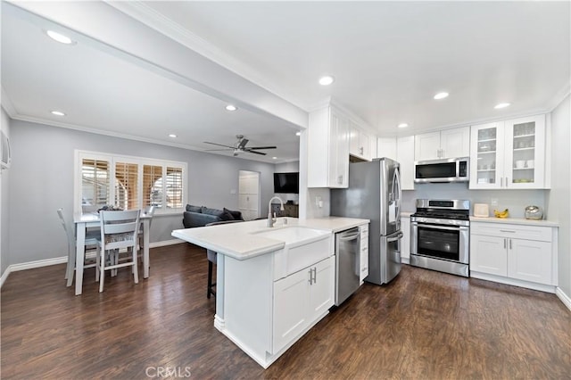 kitchen with stainless steel appliances, dark wood-style flooring, a sink, and white cabinets