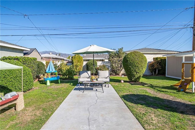 view of yard featuring a patio, an outdoor structure, and fence