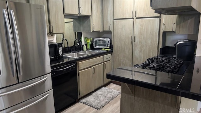 kitchen featuring dark countertops, light wood-style flooring, black appliances, a sink, and exhaust hood