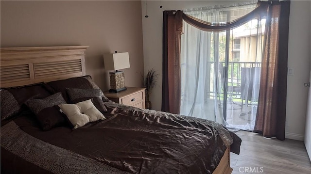 bedroom with access to outside and light wood-style flooring