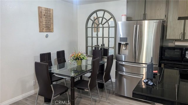 dining area with light wood-style floors and baseboards