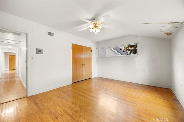 unfurnished bedroom with baseboards, visible vents, a ceiling fan, lofted ceiling, and light wood-style flooring