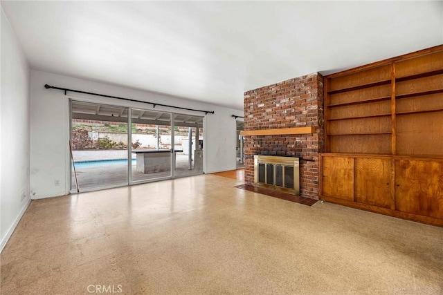 unfurnished living room featuring a fireplace and baseboards