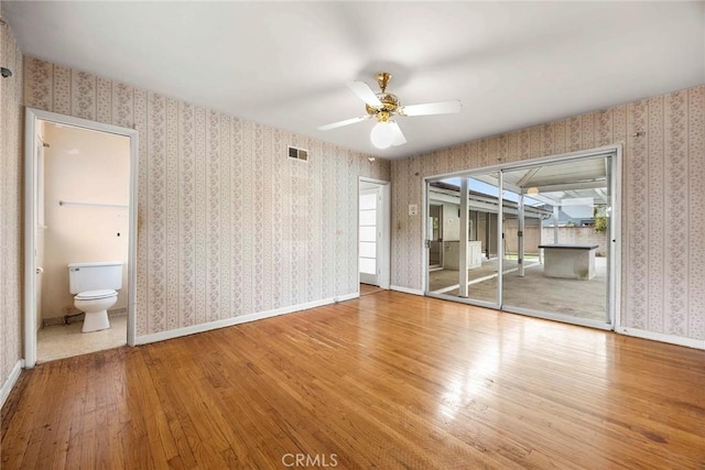 unfurnished bedroom featuring visible vents, wallpapered walls, access to outside, baseboards, and hardwood / wood-style flooring