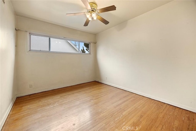 empty room featuring ceiling fan, wood finished floors, and baseboards