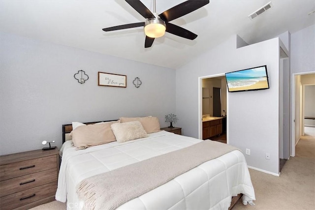 bedroom featuring lofted ceiling, visible vents, ensuite bathroom, light carpet, and ceiling fan