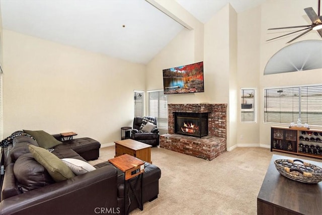 carpeted living area featuring a brick fireplace, baseboards, high vaulted ceiling, and a ceiling fan