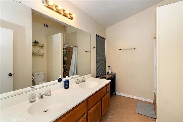 bathroom featuring toilet, tile patterned flooring, a sink, and visible vents