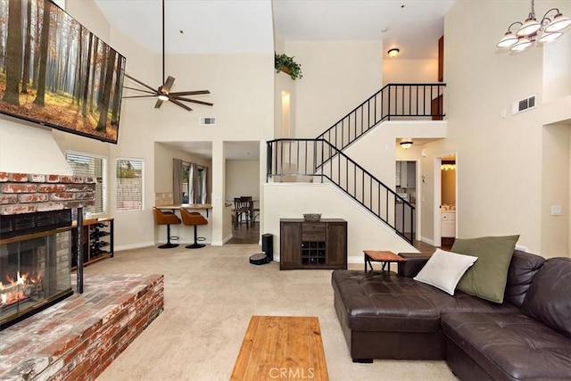 living area with carpet flooring, visible vents, baseboards, stairway, and a brick fireplace