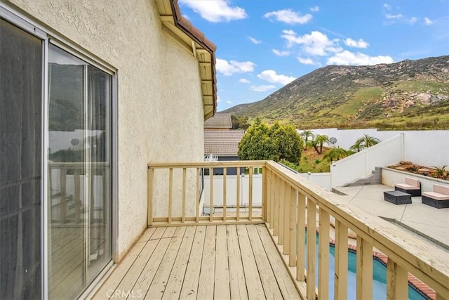 balcony featuring a water and mountain view and a patio