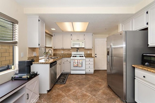 kitchen with stainless steel appliances, a sink, white cabinetry, and decorative backsplash