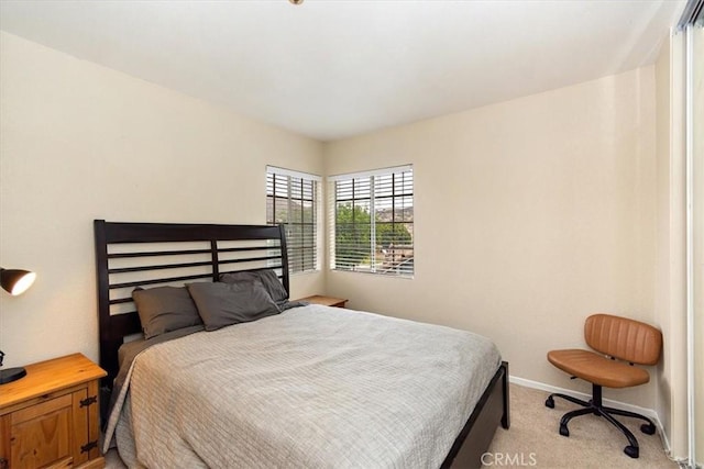 bedroom featuring light colored carpet and baseboards