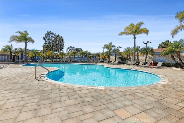 pool with fence and a patio