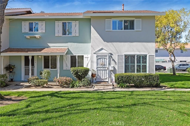 view of front of property with a front lawn and stucco siding