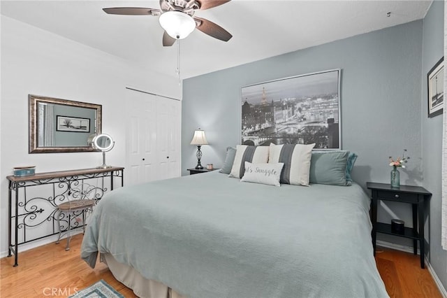 bedroom with a closet, ceiling fan, and wood finished floors