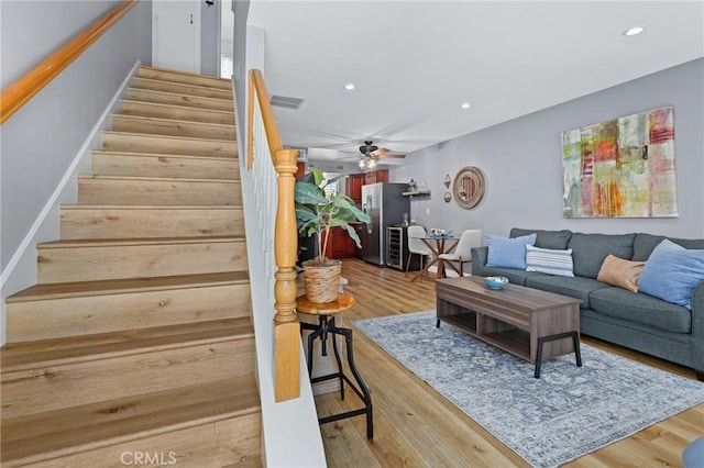 living room featuring visible vents, stairway, wood finished floors, and recessed lighting