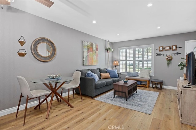 living room with light wood finished floors, recessed lighting, and baseboards