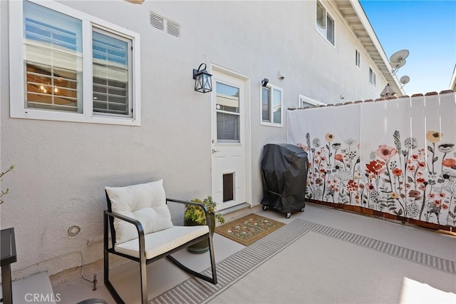 view of patio / terrace with grilling area, fence, and visible vents