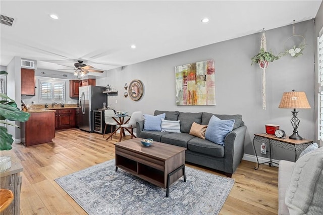 living area featuring light wood-style floors, recessed lighting, visible vents, and a ceiling fan