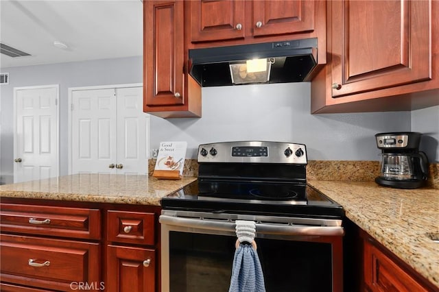 kitchen with light stone countertops, under cabinet range hood, stainless steel electric range, and visible vents