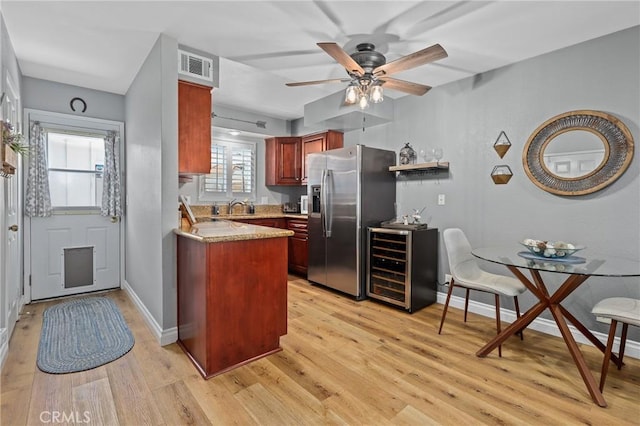 kitchen featuring stainless steel fridge, beverage cooler, visible vents, light countertops, and light wood-type flooring