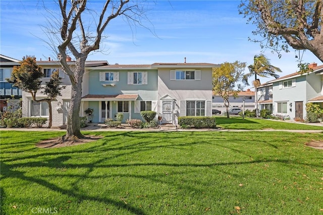 multi unit property with a front lawn and stucco siding