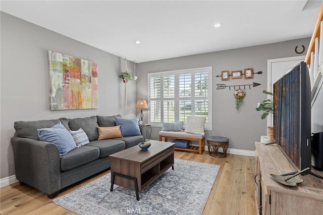 living area with light wood-type flooring, baseboards, and recessed lighting