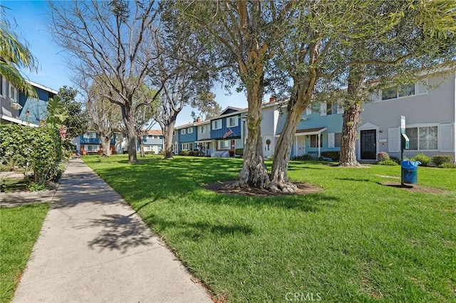 view of community featuring a residential view and a yard