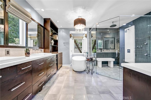 bathroom featuring a freestanding tub, a shower stall, a chandelier, and vanity