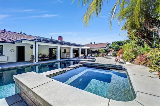 view of pool with a pool with connected hot tub and a patio area