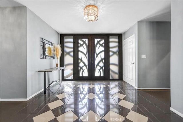 entryway with an inviting chandelier, baseboards, and french doors