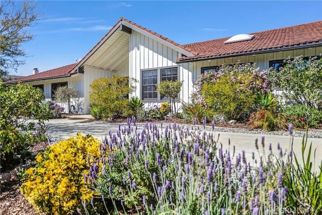 view of front of house with a tile roof and board and batten siding