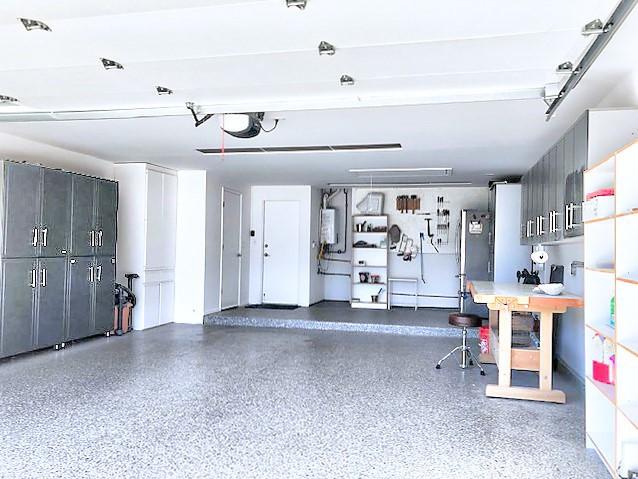 garage featuring a garage door opener and water heater