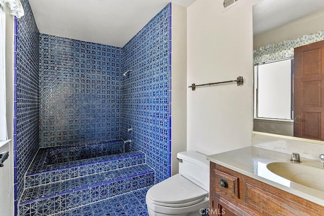 bathroom featuring visible vents, vanity, walk in shower, and toilet