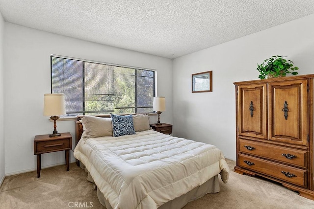 bedroom with light carpet, a textured ceiling, and baseboards