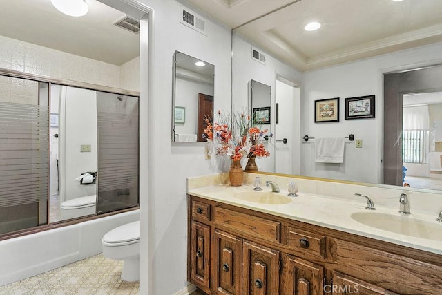 bathroom with visible vents, a sink, toilet, and bath / shower combo with glass door