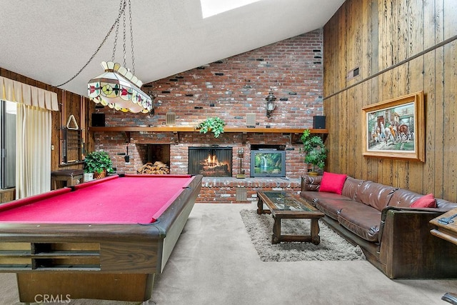 rec room with a brick fireplace, high vaulted ceiling, carpet flooring, and wood walls