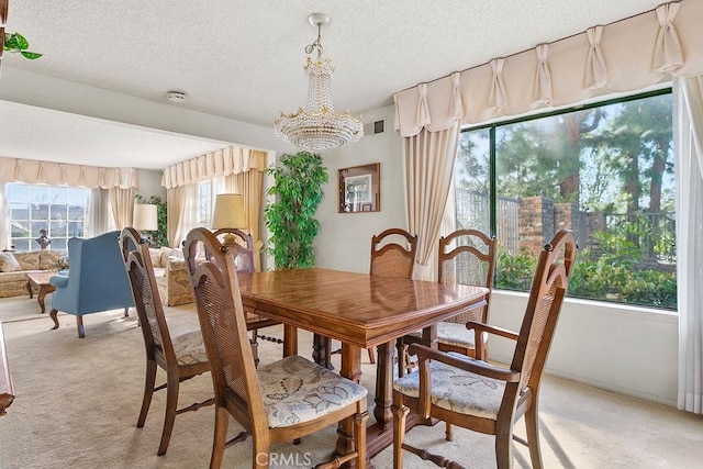 dining space featuring visible vents, a textured ceiling, and light colored carpet