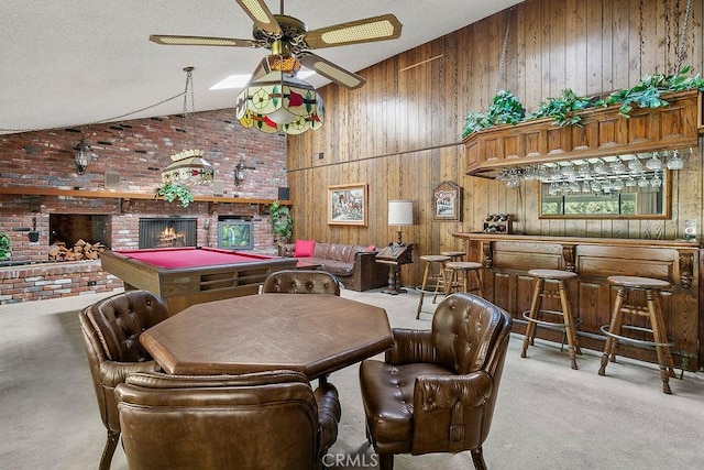 interior space with lofted ceiling, carpet, a textured ceiling, a bar, and a brick fireplace