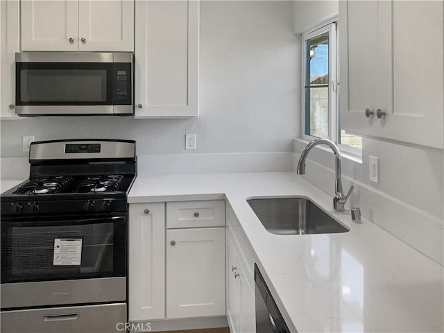 kitchen featuring white cabinetry, appliances with stainless steel finishes, and a sink