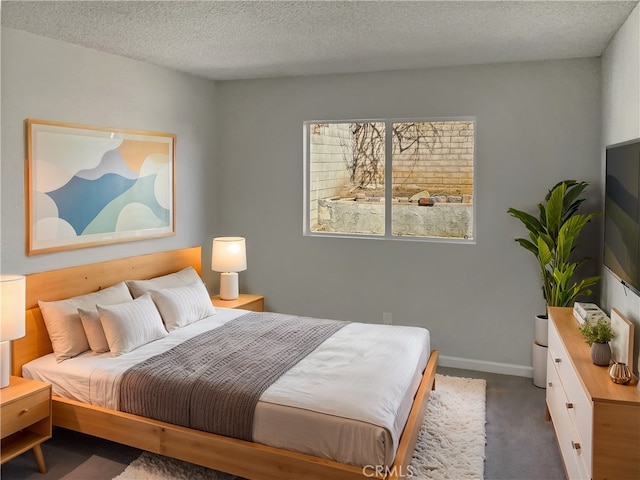 bedroom with a textured ceiling, carpet, and baseboards