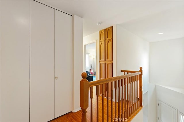 hallway with an upstairs landing and light wood finished floors