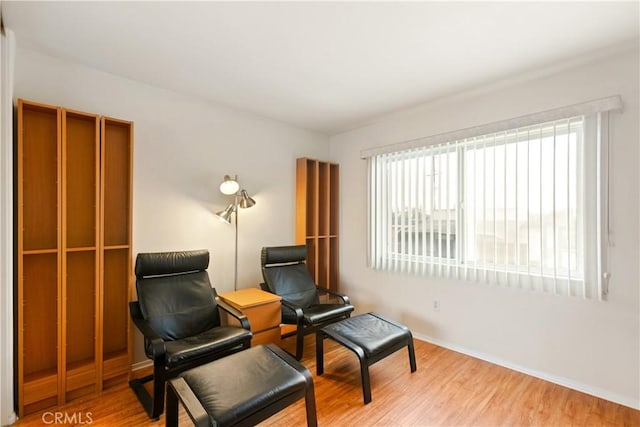 sitting room with baseboards and wood finished floors